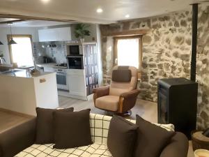a living room with a couch and a kitchen at Appartement de charme Saint-Romain in Saint-Romain