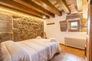 a bedroom with a bed and a stone wall at Casa ponet in Solsona +26 photos