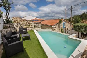 a swimming pool with two chairs in a yard at Residencia Dos Castelos in Santarém