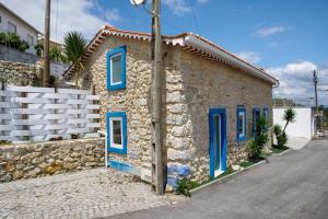 a stone house with blue doors on a street at Residencia Dos Castelos in Santarém