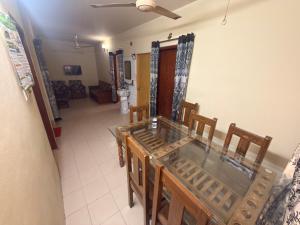 a dining room with a glass table and chairs at Garden tower,sylhet in Sylhet