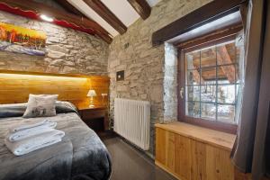 a bedroom with a bed in a stone wall at Arthemisia - Rhêmes-Notre-Dame in Rhêmes-Notre-Dame