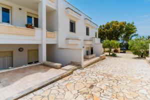 a house with a stone driveway in front of it at Residence Punta Pizzo in Marina di Mancaversa