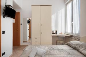 a bedroom with a bed and a desk and a television at Affittacamere Monica in Levanto