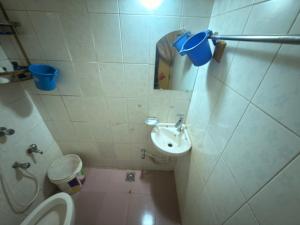 a bathroom with a toilet and a sink and a mirror at Garden tower,sylhet in Sylhet