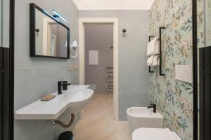 a bathroom with a sink and a toilet and a mirror at Dimora Borgo Antico Lucia in Ascea +30 photos