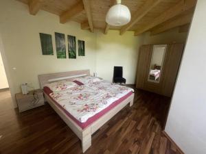 a bedroom with a bed in a room with wooden floors at Ferienwohnungen Fischbachhof in Sulzbach an der Murr