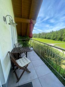 a patio with a table and a chair on a balcony at Ferienwohnungen Fischbachhof in Sulzbach an der Murr