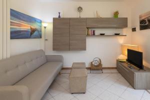 a living room with a couch and a tv at Castiglioncello Mare Apartment in Castiglioncello