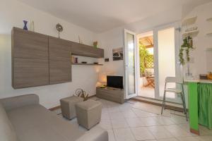 a living room with a couch and a television at Castiglioncello Mare Apartment in Castiglioncello