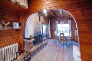 a living room with a fireplace and a table and chairs at Chalet Bühberg Alm in Bad Lauterberg