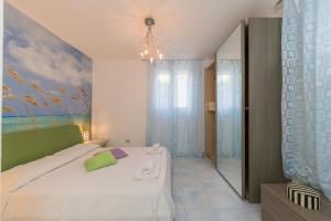 a bedroom with a bed and a painting on the wall at Castiglioncello Mare Apartment in Castiglioncello
