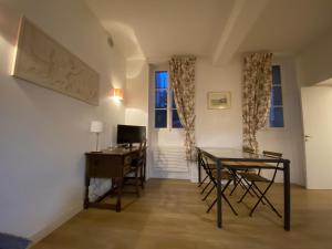 a dining room with a table and a desk at Château de Versailles 800m à pied in Versailles