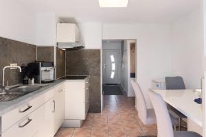 a kitchen with white cabinets and a table and chairs at Ferienhaus in Zernitz