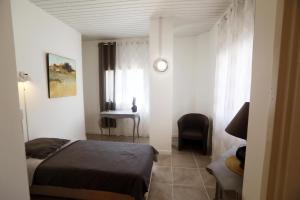 a bedroom with a bed and a chair and a desk at Villa Loudéro in Bédarieux