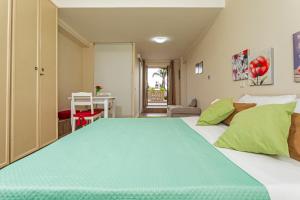 a bedroom with a large bed with green pillows at Pètra Janca in Aci SantʼAntonio