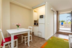a small kitchen and dining room with a table and chairs at Pètra Janca in Aci SantʼAntonio