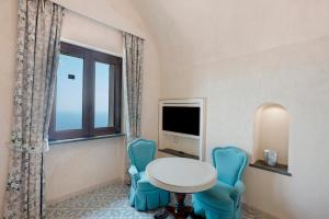 a room with a table and chairs and a window at Dimora elegante in Costa d'Amalfi in Conca dei Marini