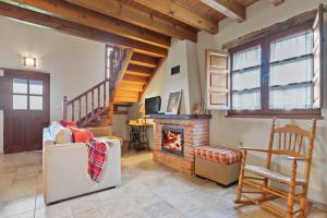 a living room with a fireplace and a staircase at La Ceriquina in Nava