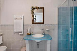 a bathroom with a blue sink and a mirror at Dimora elegante in Costa d'Amalfi in Conca dei Marini +12 photos