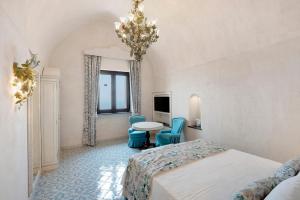 a bedroom with a bed and a table and chairs at Dimora elegante in Costa d'Amalfi in Conca dei Marini