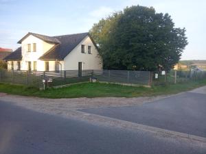 una casa bianca con una recinzione accanto a una strada di Beier a Neustrelitz