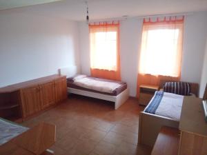 una stanza con un letto e due finestre di Beier a Neustrelitz