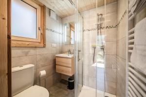 a bathroom with a toilet and a glass shower at Chalet Léonie in Abondance