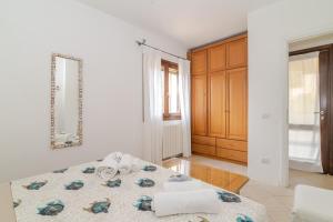a white room with a bed and a mirror at Casa Lucia San Teodoro 1 in Schifoni