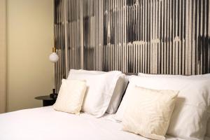 a bedroom with a bed with white pillows at Dimora Màufra in Locorotondo