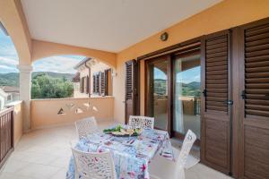 a dining room with a table and chairs on a balcony at Casa Lucia San Teodoro 1 in Schifoni