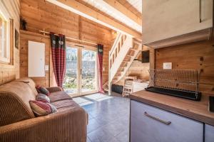 a living room with a couch and a kitchen at Chalet Léonie in Abondance