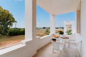 a dining room with a table and chairs and a window at Residence Punta Pizzo in Marina di Mancaversa
