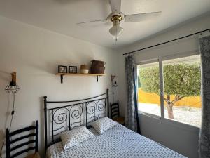 a bedroom with a bed with a ceiling fan and a window at Villa Miantojo in Mazarrón