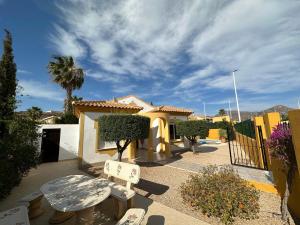 a patio with two chairs and a building with a palm tree at Villa Miantojo in Mazarrón