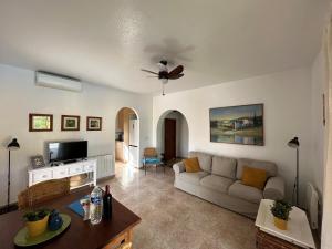 a living room with a couch and a ceiling fan at Villa Miantojo in Mazarrón