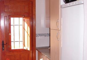 a kitchen with a wooden door and a window at Villa Miantojo in Mazarrón