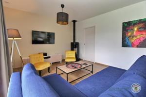 a living room with a blue couch and a table at Ty mam goz in Trébeurden