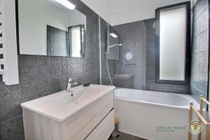 a bathroom with a sink and a bath tub and a sink at Ty mam goz in Trébeurden +37 photos