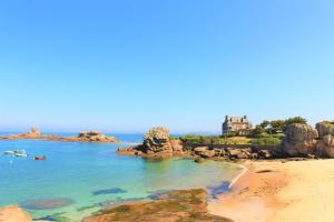 a view of a beach with a house in the distance at Ty mam goz in Trébeurden