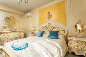 a bedroom with a large white bed with blue pillows at Villetta Mare e Monti in Mascali
