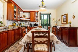a kitchen with wooden cabinets and a table at Villetta Mare e Monti in Mascali +22 photos