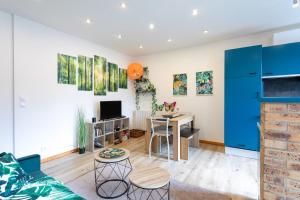 a living room with blue cabinets and a table at Oasis tropicale a Cleguerec in Cléguérec