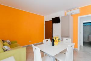 a living room with a white table and orange walls at Casa Vacanza Susanna in Otranto