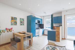 a kitchen with blue cabinets and a table and chairs at Oasis tropicale a Cleguerec in Cléguérec