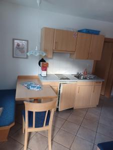 a kitchen with wooden cabinets and a table and a sink at App Sonne Nr 14 in Lutago