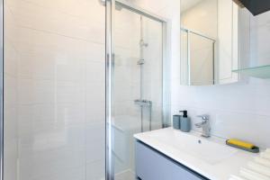a white bathroom with a sink and a shower at Oasis tropicale a Cleguerec in Cléguérec +18 photos