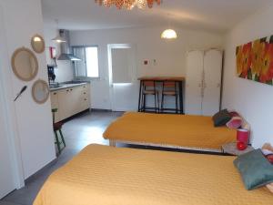 two beds are in a room with a kitchen at Nova Aurora in Lousã +17 photos