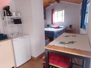 a kitchen with a table and a bed in a room at Nova Aurora in Lousã