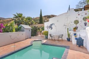 a swimming pool in the backyard of a house at Cortijo La Alamea in Almuñécar